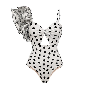 Close-up of retro polka dot swimsuit with ruffle trim and chest cut-out detail