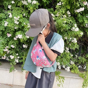 Pink toddler fanny pack with cartoon unicorn print and adjustable strap in outdoor setting