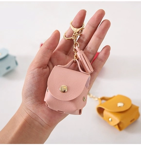 Detail of pink lychee leather case for AirPods with metal clasp and tassel charm