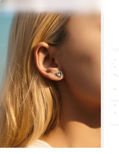 Gros plan d'un modèle portant des boucles d'oreilles cœur turquoise en argent