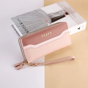 Close-up of women's long double-zipper wallet featuring pink color-block leather texture