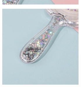 Detail of transparent comb handle filled with cute holographic flower-shaped sequins
