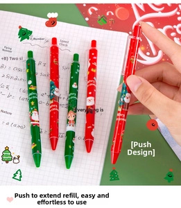 Close-up of festive Christmas ballpoint pens with Santa patterns on a notebook