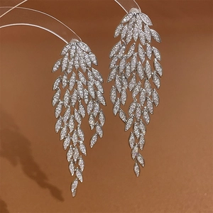 Macro detail of long leaf tassel earrings featuring silver alloy and zircon inlay