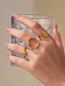 Detailed view of three 18k gold plated stainless steel rings featuring stars and zircon
