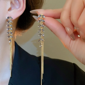 Detail of leaf-shaped crystals and long gold tassel chains on an elegant earring
