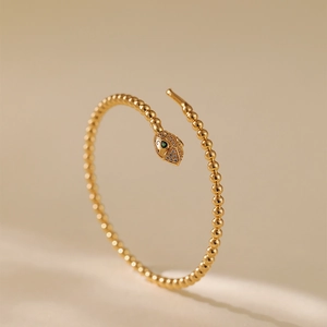 Elegant 18K gold-plated snake bracelet with sparkling crystals and green gem eyes