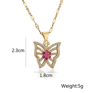 Detail view of a 2.3cm gold butterfly pendant with sparkling stones and pink flower core