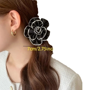 Elegant black camellia hair scrunchie with white edges on model, 7cm floral hair tie