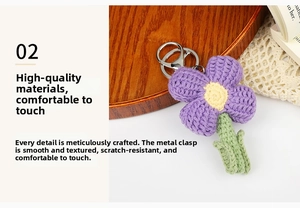 Macro detail of handmade crochet purple flower keychain with silver metal ring on wood