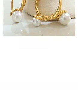 Macro shot of gold twist earrings with white pearls in a retro French style detail