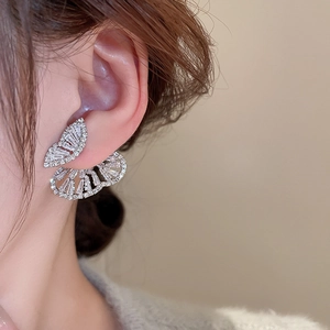 Detail of silver butterfly earrings with sparkling cubic zirconia on a female model