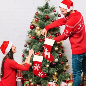 Close-up of festive red knit Christmas stockings with snowflake and reindeer patterns
