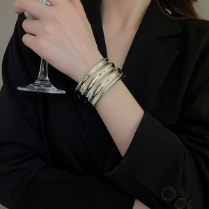 Close-up of wavy wide metal cuff bracelet with silver liquid mirror finish