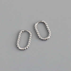 Macro shot of silver U-shaped beaded hoop earrings showing the S925 hallmark detail