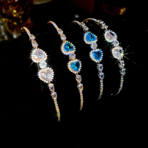 Detail of luxury heart-shaped zircon bracelets with sea blue and clear crystals in gold and silver