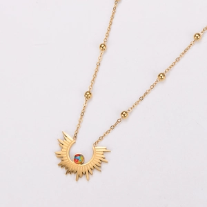 Detail of gold sunburst pendant with colorful center bead and beaded satellite chain