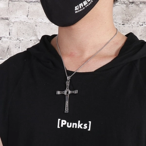 Detail of a punk-style cross pendant with black zircon stones on a square link chain