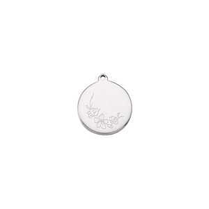 Macro shot of silver stainless steel pendant with detailed floral engraving for jewelry