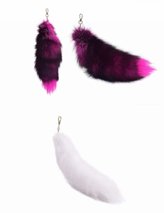 Detail view of large fox fur tail keychains in purple gradient and pure white fur