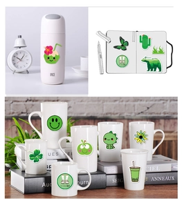 Close-up of green VSCO aesthetic stickers on a water bottle and notebook journal