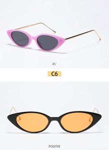 Detail of cat eye sunglasses in pink and black frames with slim gold metal temples