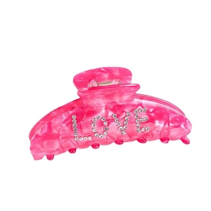 Pink acrylic claw clip with sparkling rhinestone LOVE text on a clean white background