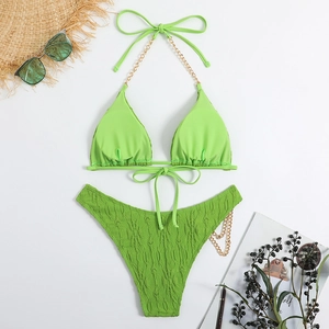 Detailed flat lay of lime green bikini with gold chain straps and textured fabric