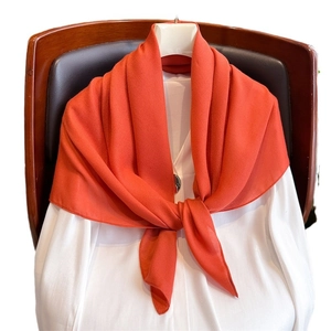 Orange linen cotton scarf elegantly draped on a chair for autumn winter styling