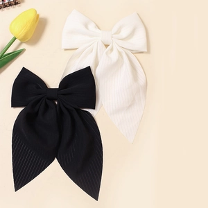 Detailed texture of black and white ribbon hair bows with soft striped fabric pattern