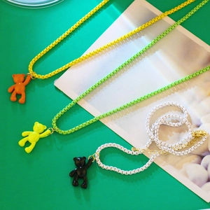 Close-up of colorful teddy bear necklaces with matching painted chain links in vibrant hues