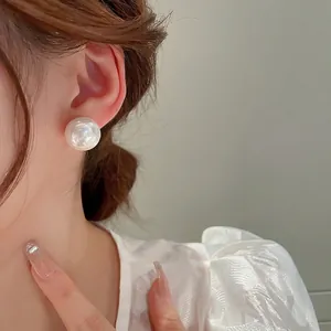 Classic 12mm white pearl stud earrings on model for a minimalist fashion look