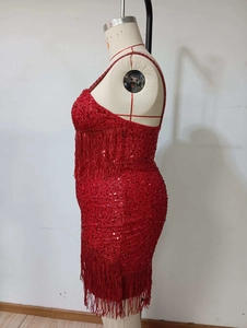 Detail of red sequined dress showing delicate fringe accents and shimmering texture