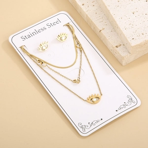 Macro view of gold stainless steel layered necklace and stud earrings with heart charms