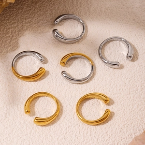 Minimalist C-shaped open rings in gold and silver finish on textured stone surface