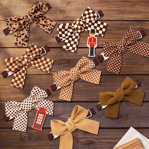 Flat lay of eight autumn-style pet bow ties in leopard, plaid, and polka dot patterns