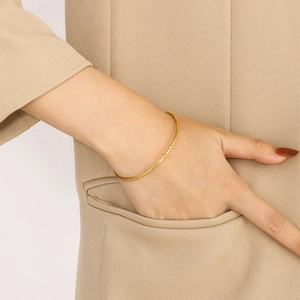 Minimalist 18K gold-plated C-shaped open cuff bracelet styled on a model's wrist