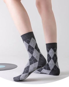 Close-up of diamond pattern crew socks in dark gray cotton worn by a model