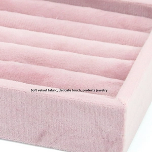 Detail of pink velvet jewelry tray with wavy slots for rings and stud earrings