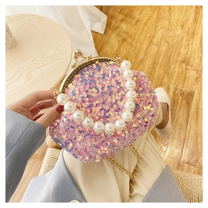 Detailed view of a pink sequin shell bag featuring a luxury faux pearl handle strap