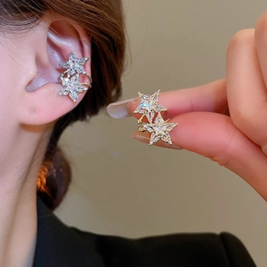 Macro shot of double-layer star ear cuff with zircon crystals showing on ear and in hand