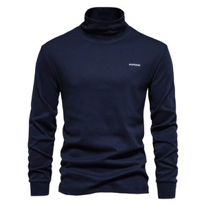 Detailed close-up of dark blue knit sweater with turtleneck and AIOPESON chest logo