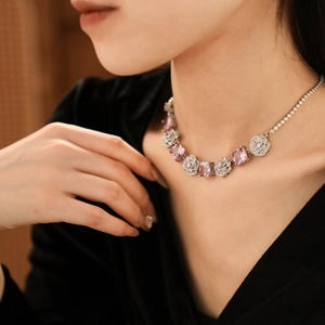 Detailed view of necklace featuring pink square gemstones and silver floral elements