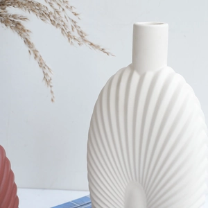 Minimalist white ceramic vase with radial shell texture in a Nordic home decor style