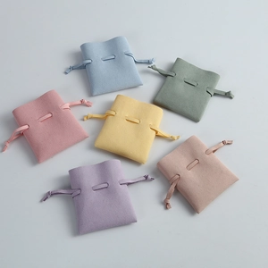 Close-up of colorful microfiber drawstring jewelry pouches in various pastel shades