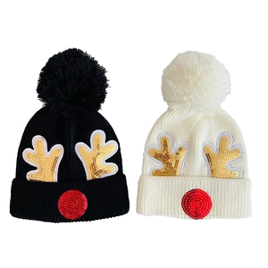 Knit Christmas hats with gold sequin reindeer antlers and fluffy pom poms in black and white