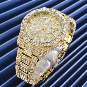 Luxury men's gold quartz watch with full iced-out crystals and date window on blue texture