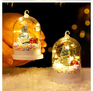 Detail of Christmas tree in glass globe with warm LED lights and bokeh effect