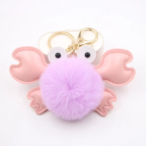 Pink and purple plush crab keychain with gold metal ring on a clean white background