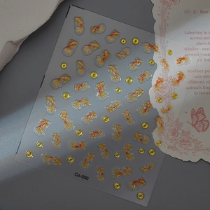 Macro detail of goldfish nail stickers with gold glitter accents and koi fish patterns